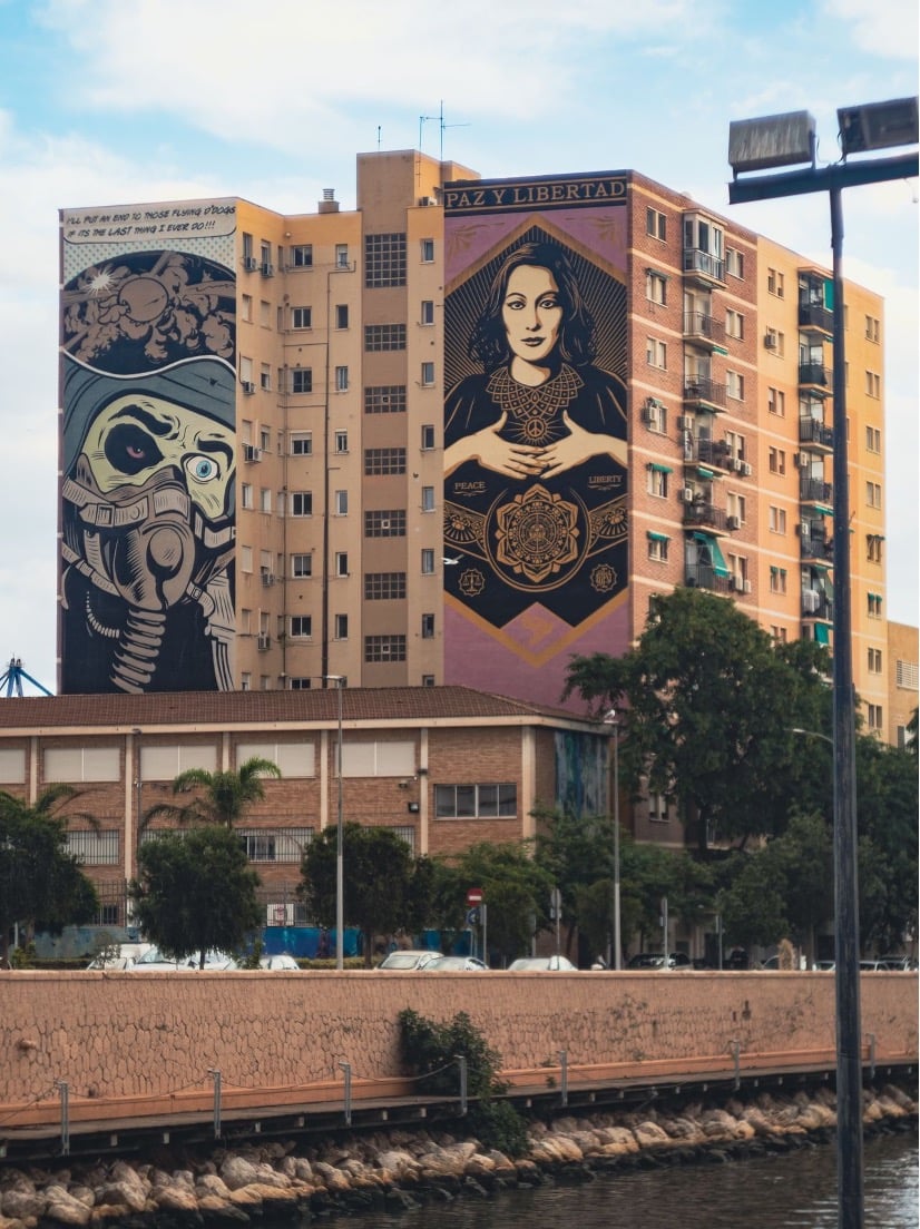 Mural de arte urbano de gran formato en el barrio Soho de Málaga, el Barrio de las Artes, con edificios residenciales al fondo