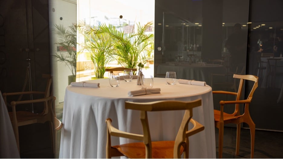 Mesa preparada en el comedor del restaurante Sollo, en Higuerón Resort, con vistas a la vegetación exterior