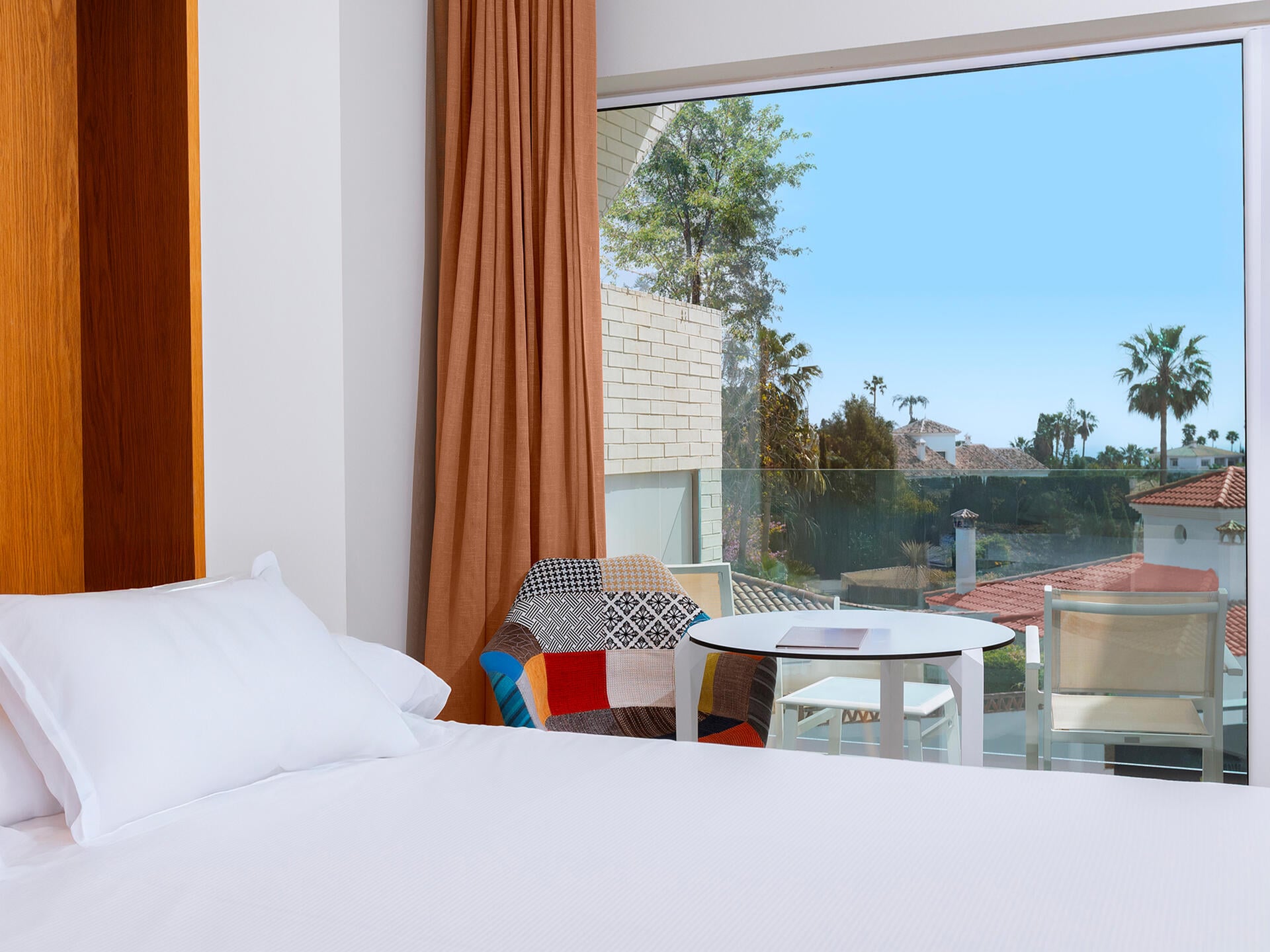 Zona de descanso y terraza con vistas al entorno de Fuengirola desde la Habitación con cama King del Higuerón Hotel Curio Collection by Hilton